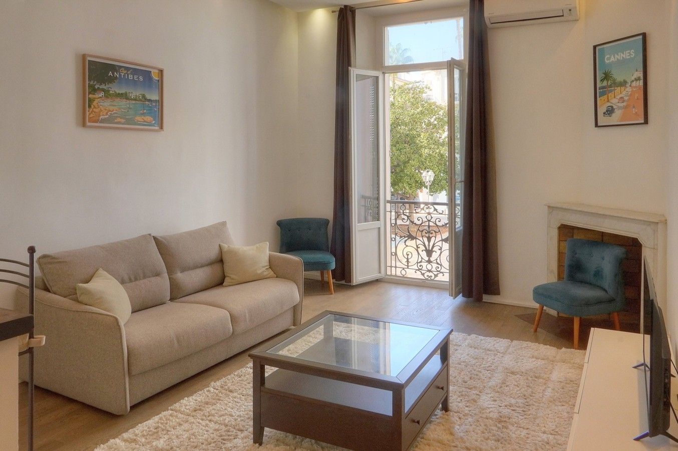 A living room with a sofa, two armchairs, a glass coffee table, and a fireplace.