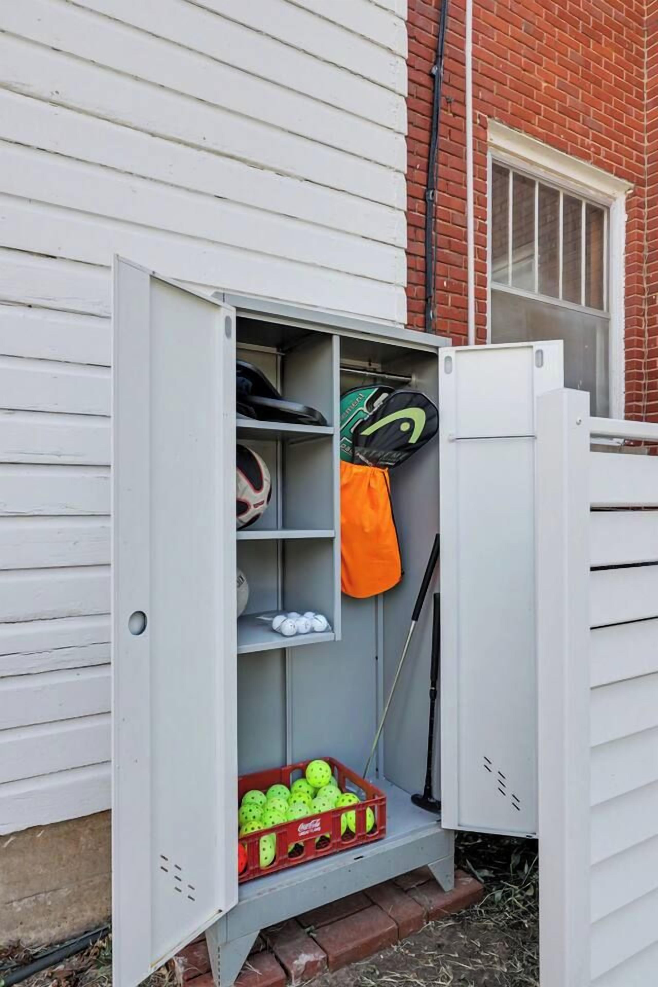 A utility box with sports equipment, including a soccer ball, a tennis racket, and a badminton racket.