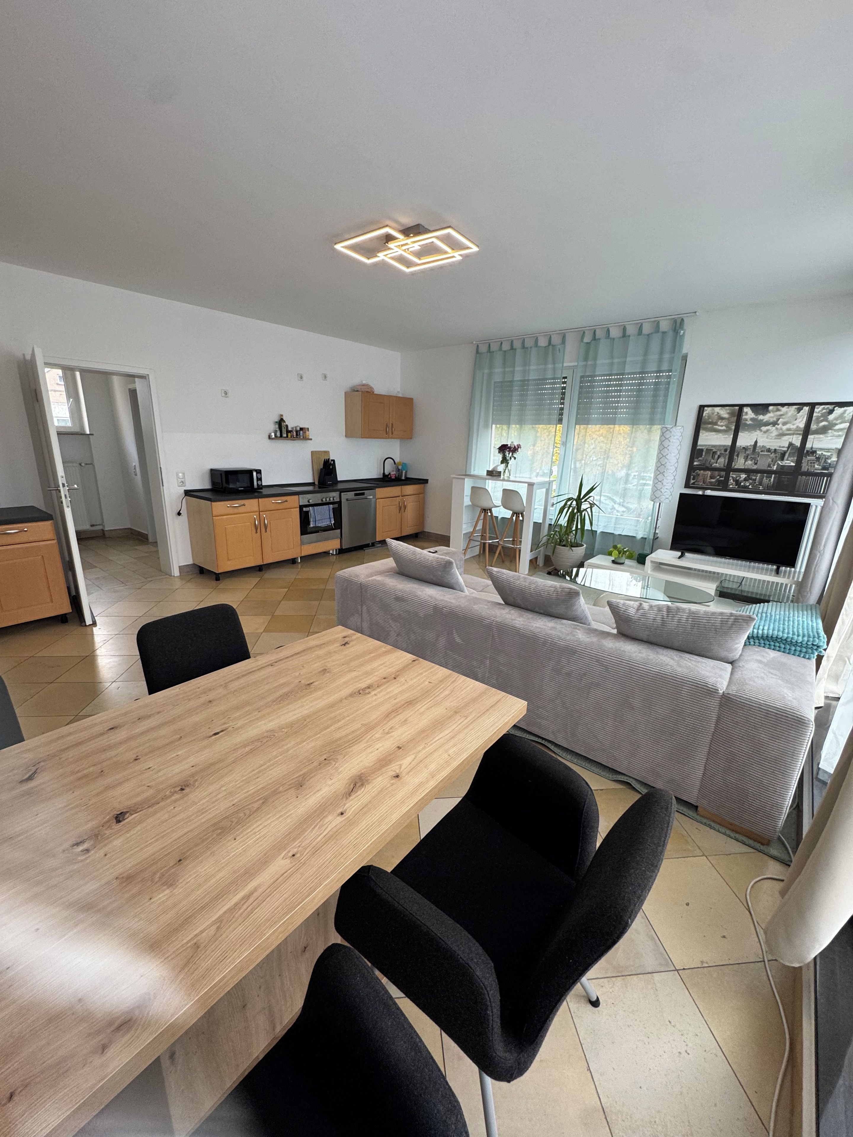 A modern living space with a dining area, kitchen, and seating area.