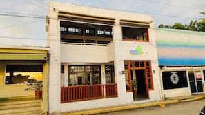 Un edificio de dos plantas con un cartel que dice 'Hotel Oceano Vista' y una entrada visible.