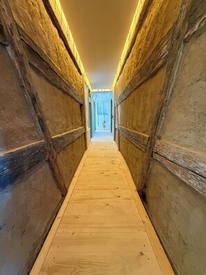 A narrow wooden corridor with a wooden floor and walls, leading to an open area with a door at the end. - Landhaus Ziemetshausen – 10 Schlafzimmer, Garten und Platz für 20 Personen (Ziemetshausen)