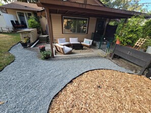 Ein Garten mit einer Terrasse, Sitzgelegenheiten im Freien und einer Holzterrasse.