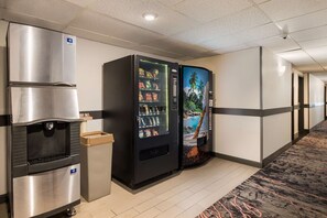 Ein Hotelgang mit Wasserspender, Verkaufsautomaten und Wandgemälde.