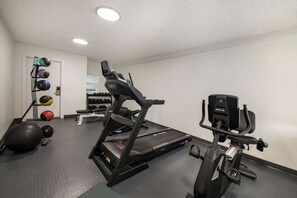 Et fitnessrum med løbebånd, motionscykel og diverse træningsbolde.