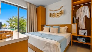 Una camera d'albergo con un letto grande, un armadio in legno, una toeletta con specchio e vista sull'esterno.