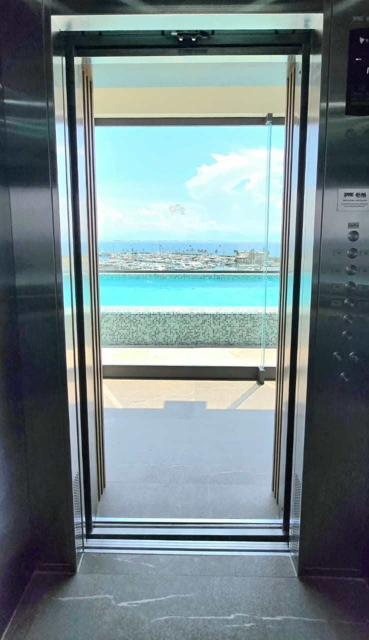 Un ascenseur offrant une vue sur une plage et un port de plaisance.