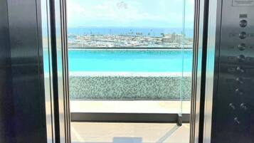 Un ascenseur offrant une vue sur une plage et un port de plaisance.