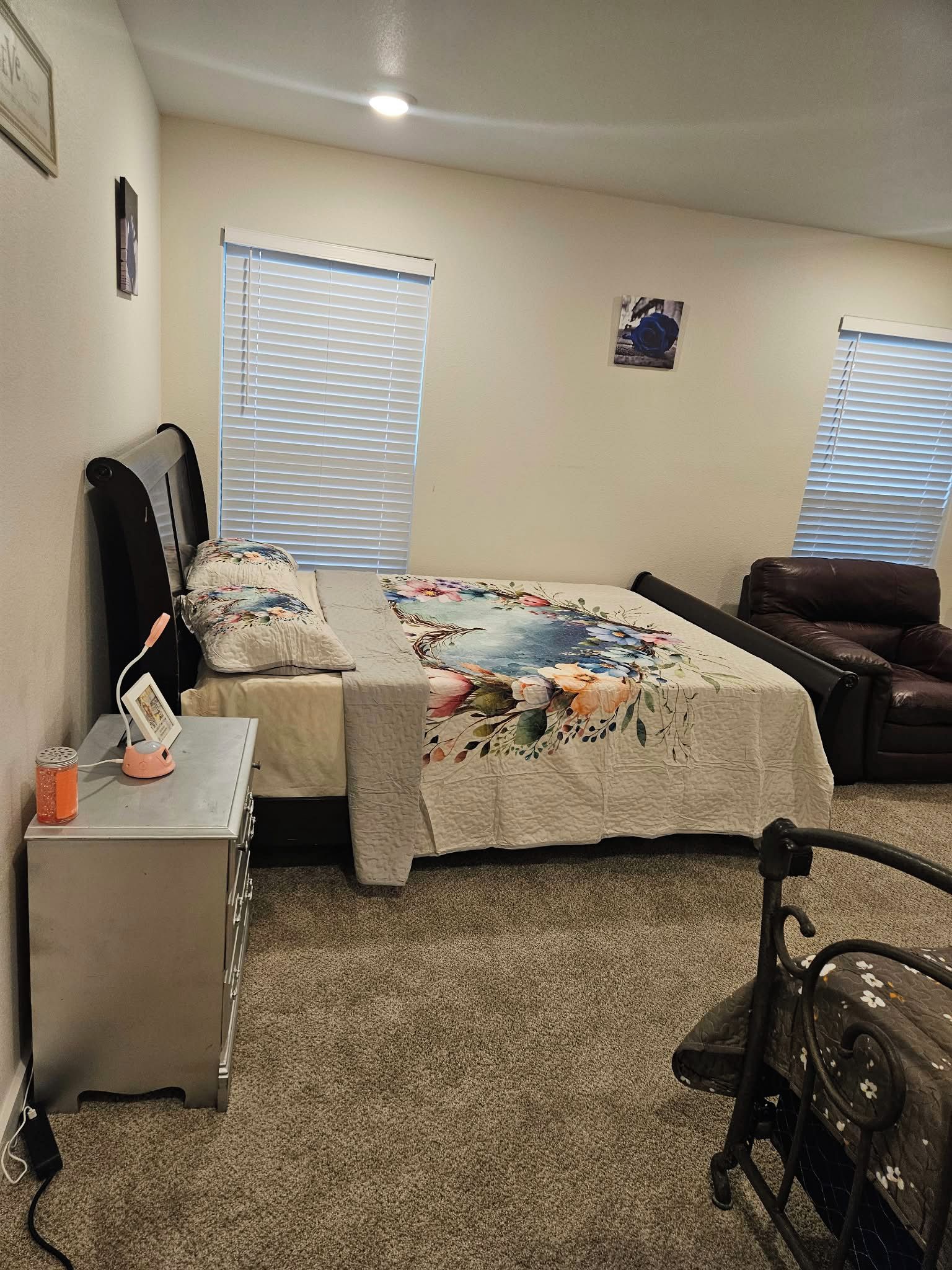 A bedroom with a bed, a desk, a chair, and a window.