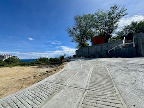 A concrete pathway leading to a building with a brick wall and a staircase. - Ruby & Antonella (San Pedro Pochutla)