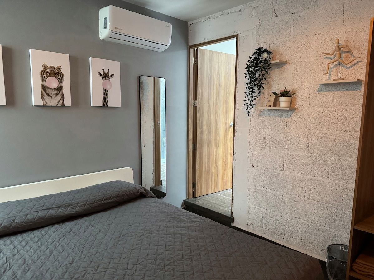 Een slaapkamer met een bed, een spiegel en kunst aan de muur.