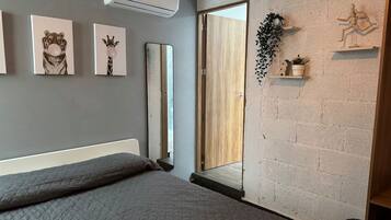 Een slaapkamer met een bed, een spiegel en kunst aan de muur.