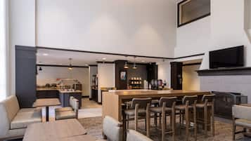 A modern bar area with seating and a coffee station.