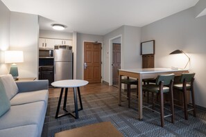 A compact living space with a kitchenette, a dining area with a table and chairs, a sofa, and a lamp. - Accessible 1BR Suite | Free Daily Breakfast + Pool (Dublin)