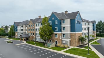 A multi-story hotel with a stone facade, blue and grey exterior, and a parking lot in front.