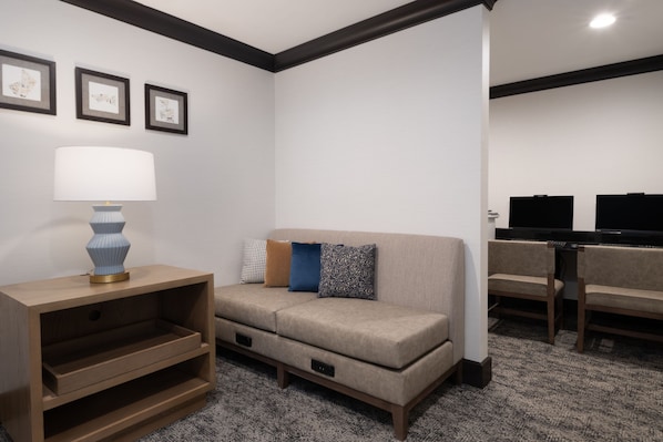 A modern living room with a sofa, a side table, a lamp, and a flat-screen TV. - King Bed 1BR Suite w/ Free Breakfast, Pool & Gym (Dublin)