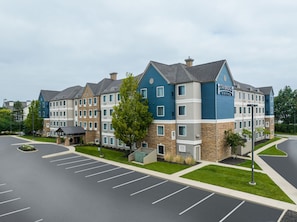 A multi-story hotel with a stone facade, blue and grey exterior, and a parking lot in front. - 2-Double 1BR Suite w/ Daily Breakfast Incl. + Pool (Dublin)