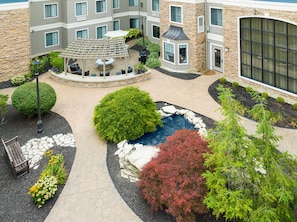 A courtyard with a central fountain, surrounded by a variety of plants and a seating area. - 2-Double 1BR Suite w/ Daily Breakfast Incl. + Pool (Dublin)