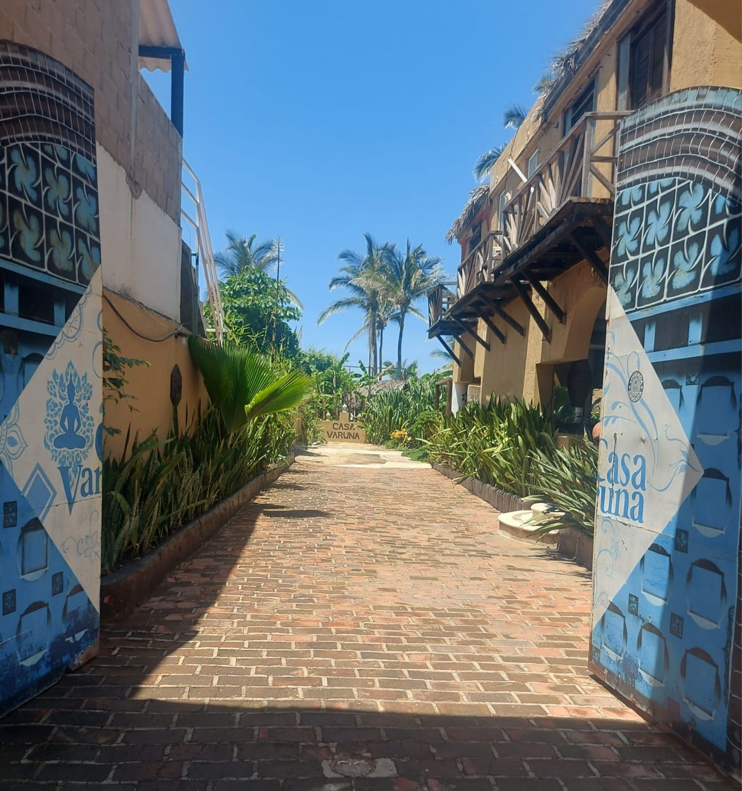 A paved pathway leading to a building with a sign reading 'Casa Varuna.'