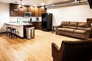 Una cocina moderna con armarios de madera, un refrigerador de acero inoxidable y un microondas integrado.