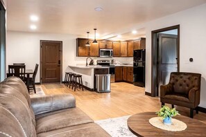 A modern kitchen with wooden cabinets, a stainless steel refrigerator, and a built-in microwave. - Exclusive Full-Complex Retreat: Reserve All 7 Suites & Common Areas (Brillion)