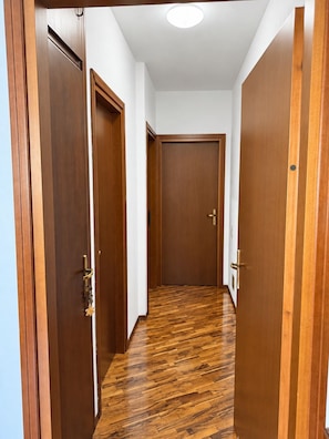 Un couloir avec des portes en bois et un plancher en bois.