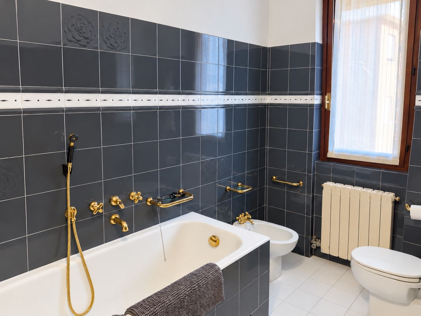 A modern bathroom with a bathtub, a shower, a toilet, and a bidet.