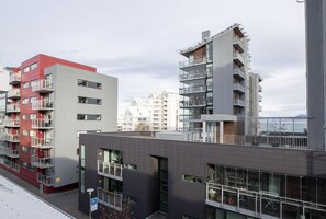 A multi-story residential building with balconies, large windows, and a parking sign. - Welcome Apartments (Reykjavik)
