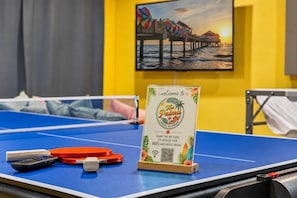 A ping pong table with a welcome sign, a QR code, and a remote control. - Largo Family Home with Pool & Mini Golf (largo)