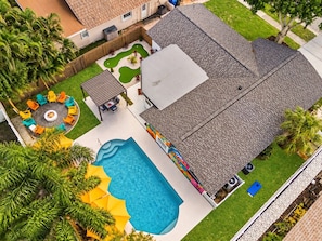 A residential property with a swimming pool, patio furniture, and a fenced backyard. - Largo Family Home with Pool & Mini Golf (largo)