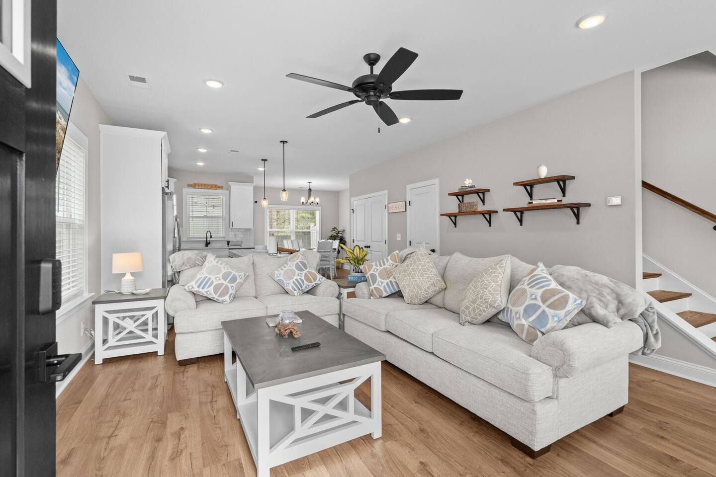 A modern living room with a sofa, coffee table, and a ceiling fan.