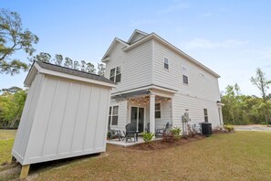 A two-story house with a covered porch and a small shed. - Your Brand New Beach Retreat! (Pawleys Island)