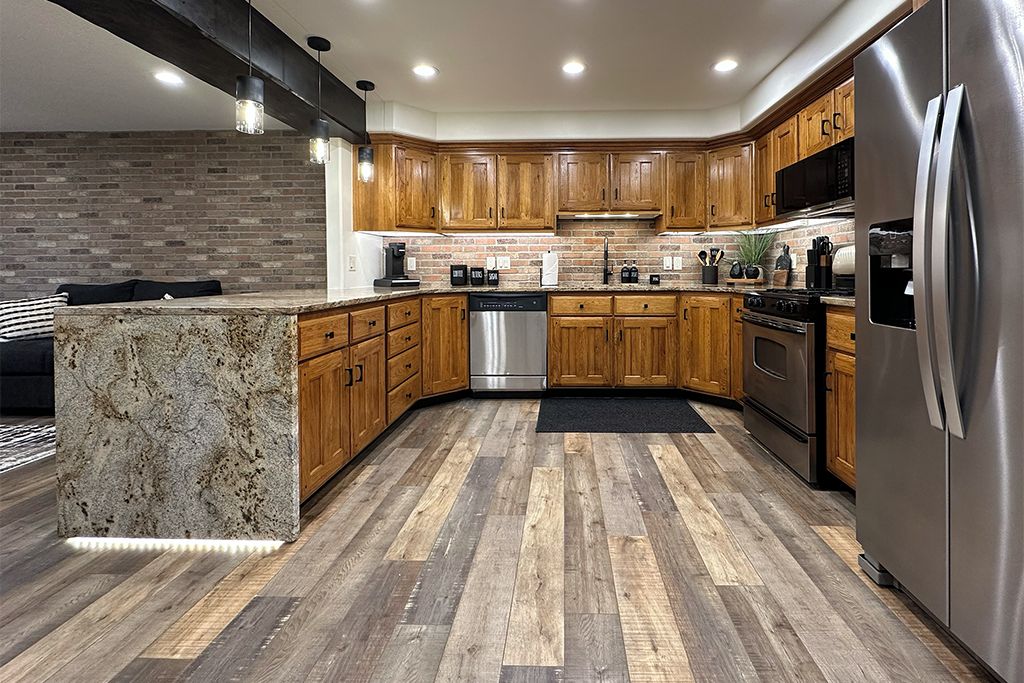 A modern kitchen with wooden cabinets, stainless steel appliances, and a granite countertop.