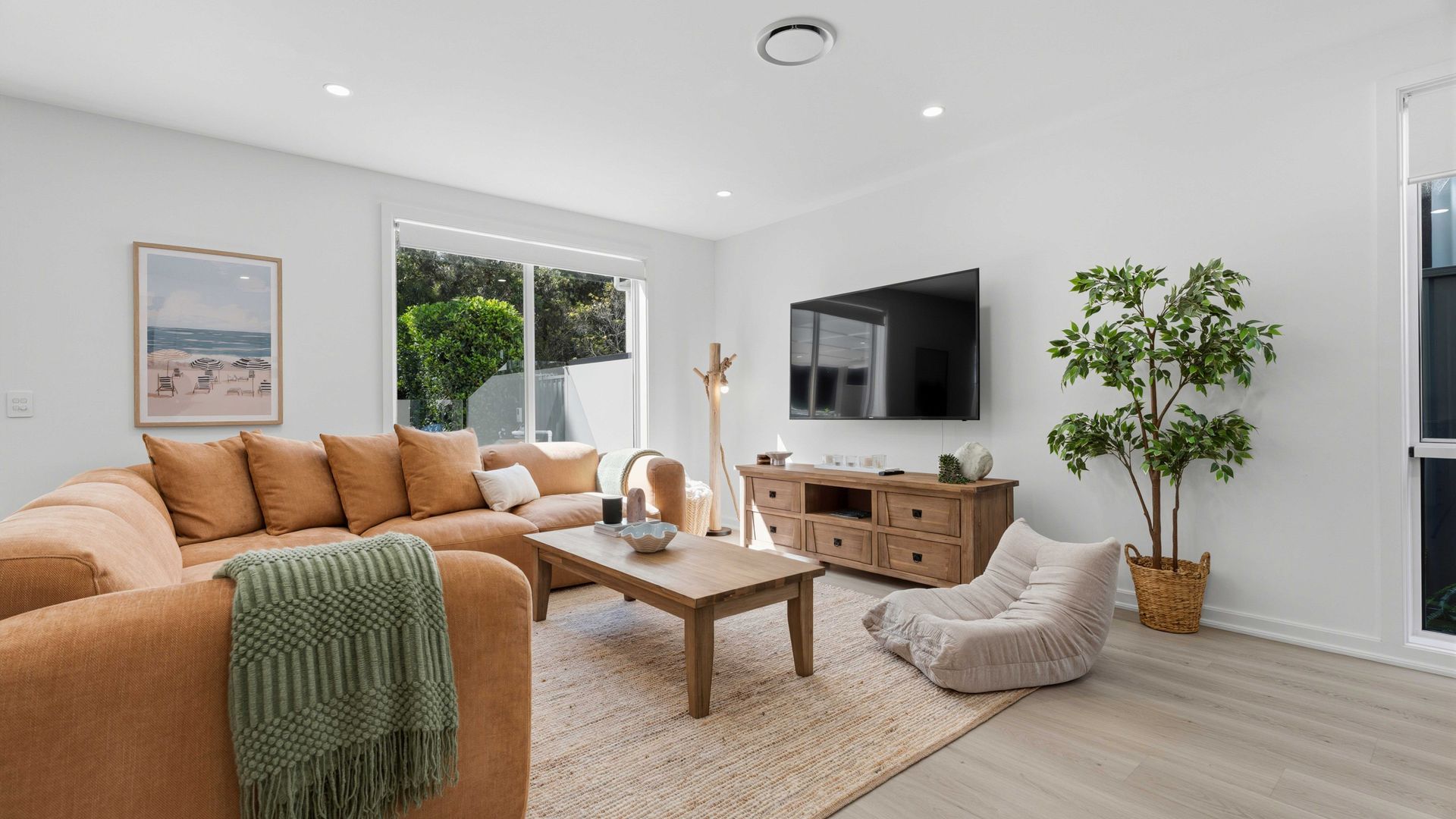A modern living room with a sofa, coffee table, and a TV.