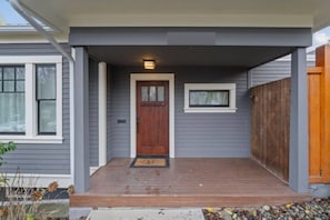 A house with a front porch, a wooden door, and a small window above it. - Spacious 4BR/2BA Home @Seattle | Ping Pong & BBQ (Seattle)