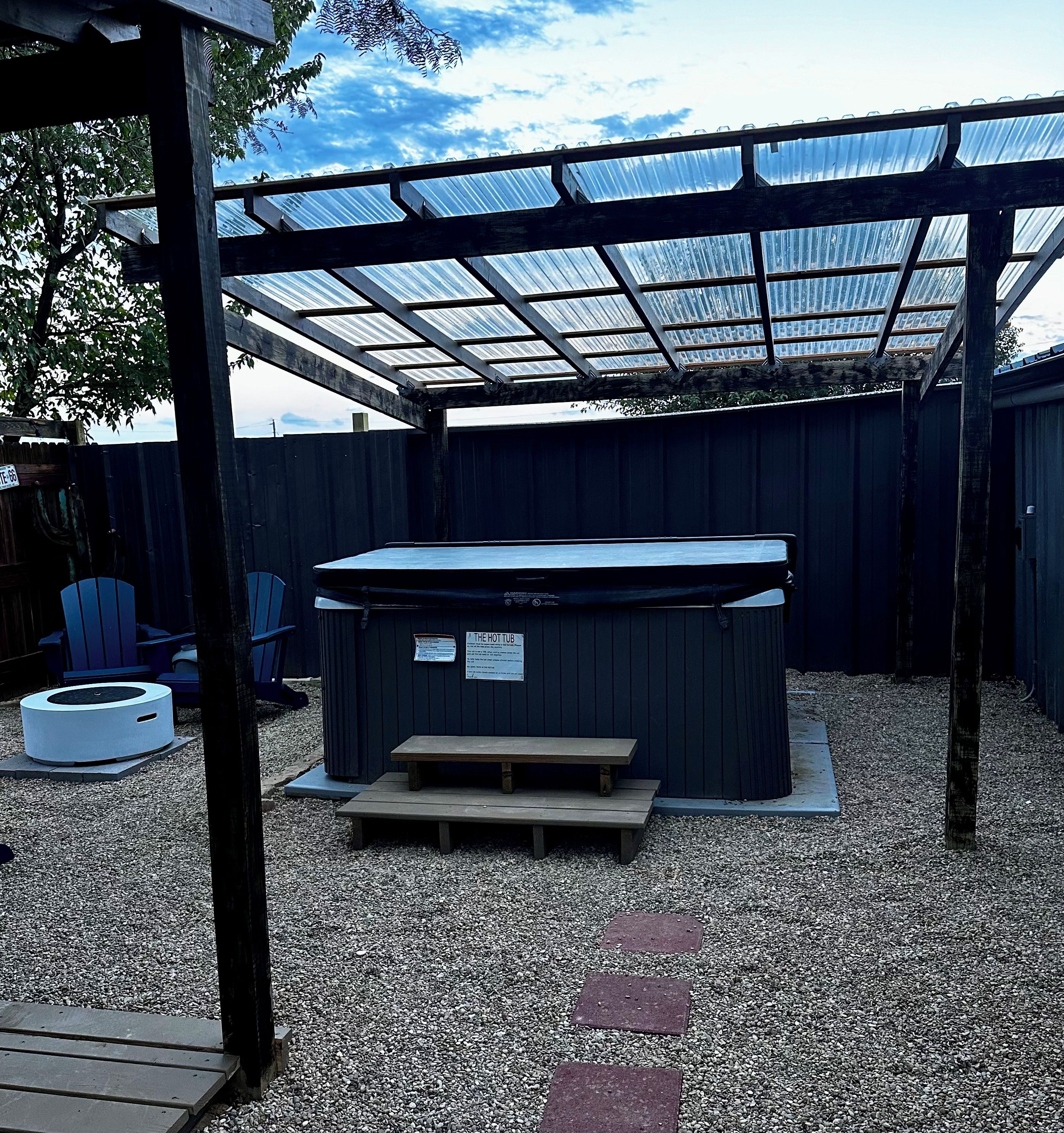 Ein Whirlpool unter einer überdachten Terrasse mit Kiesboden.
