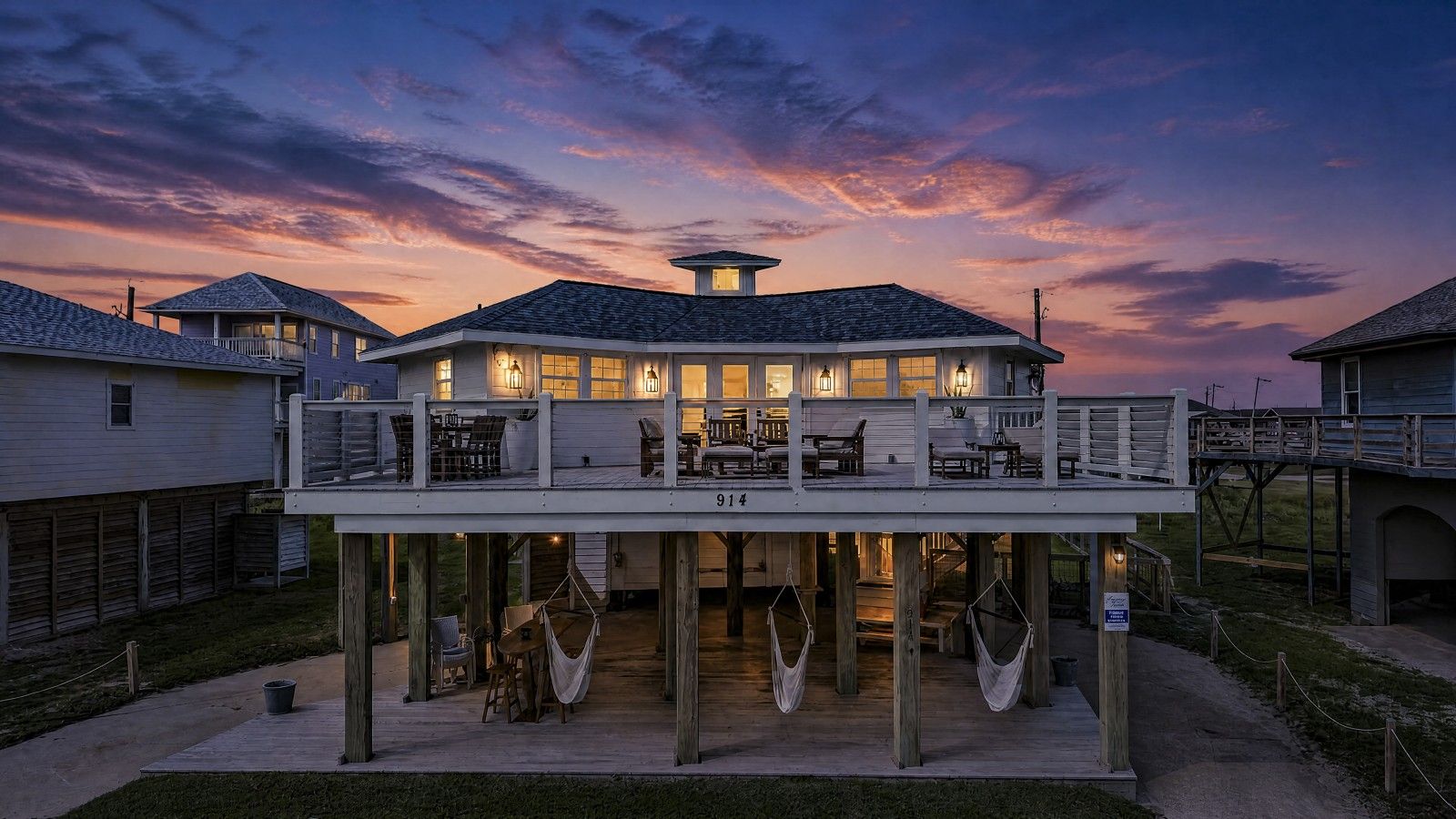 A waterfront property with a covered deck, outdoor seating, and a view of the water.