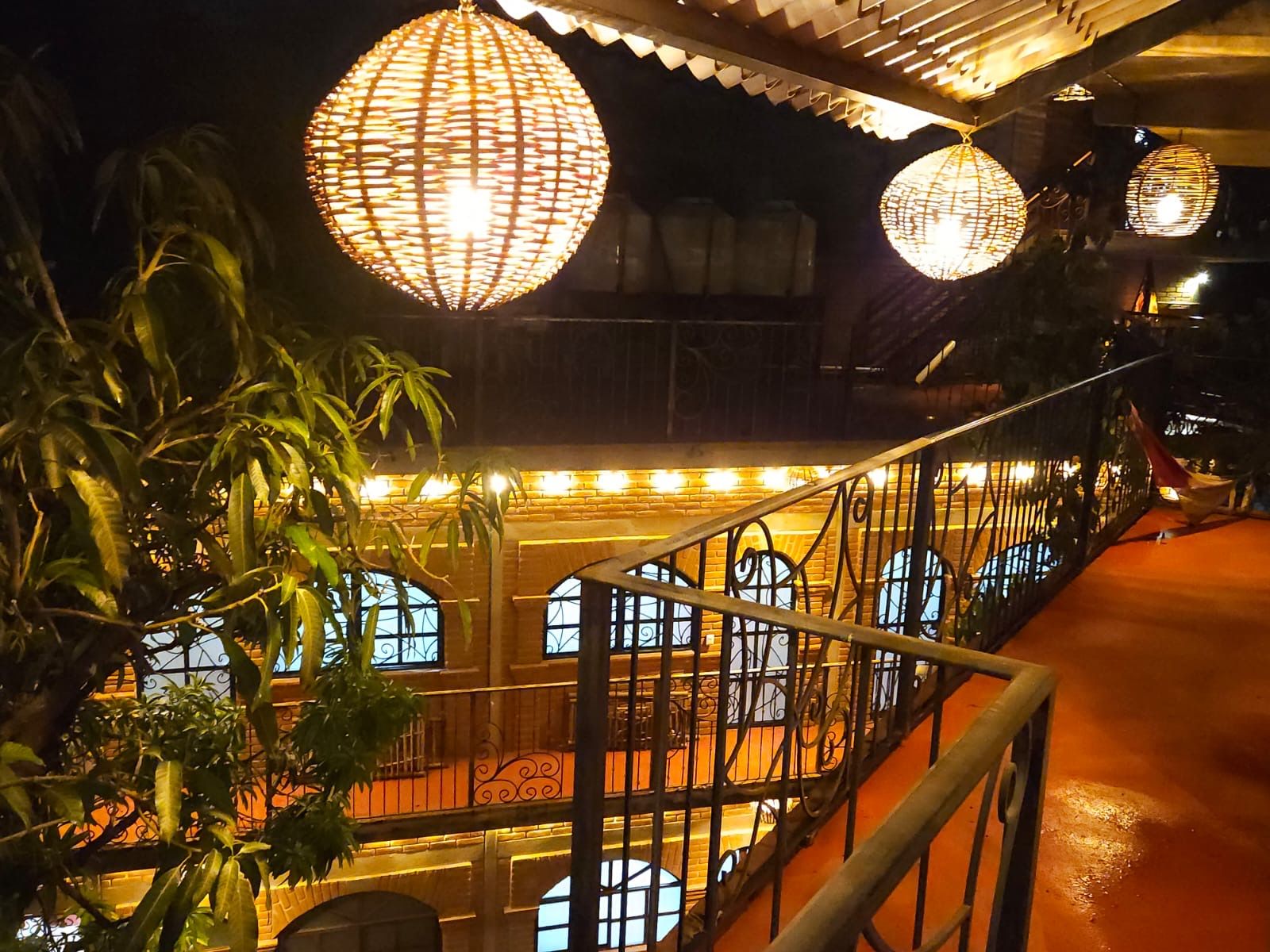 Una escalera con barandales ornamentales y una balaustrada, que conduce a un balcón con vistas al interior.