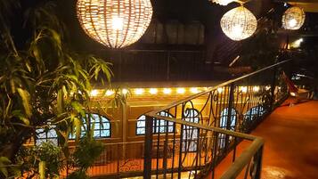 Una escalera con barandales ornamentales y una balaustrada, que conduce a un balcón con vistas al interior.