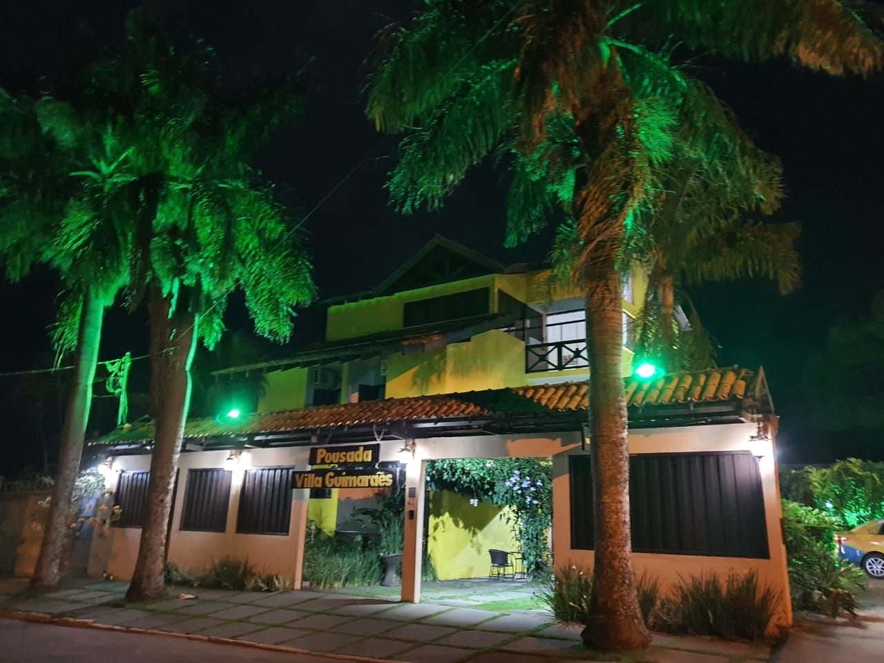 Un edificio de dos pisos con un letrero que dice 'Pousada Villa Gumardes'.