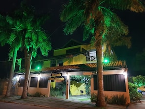 A two-story building with a sign reading 'Pousada Villa Gumardes.'