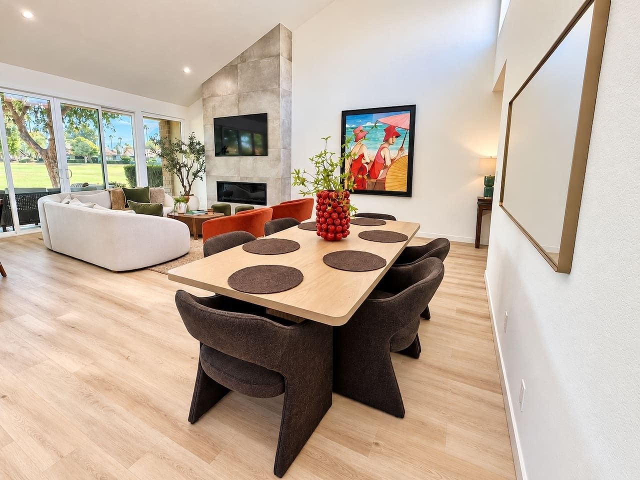 Un espace de repas moderne avec une table en bois, des chaises foncées et un canapé blanc.