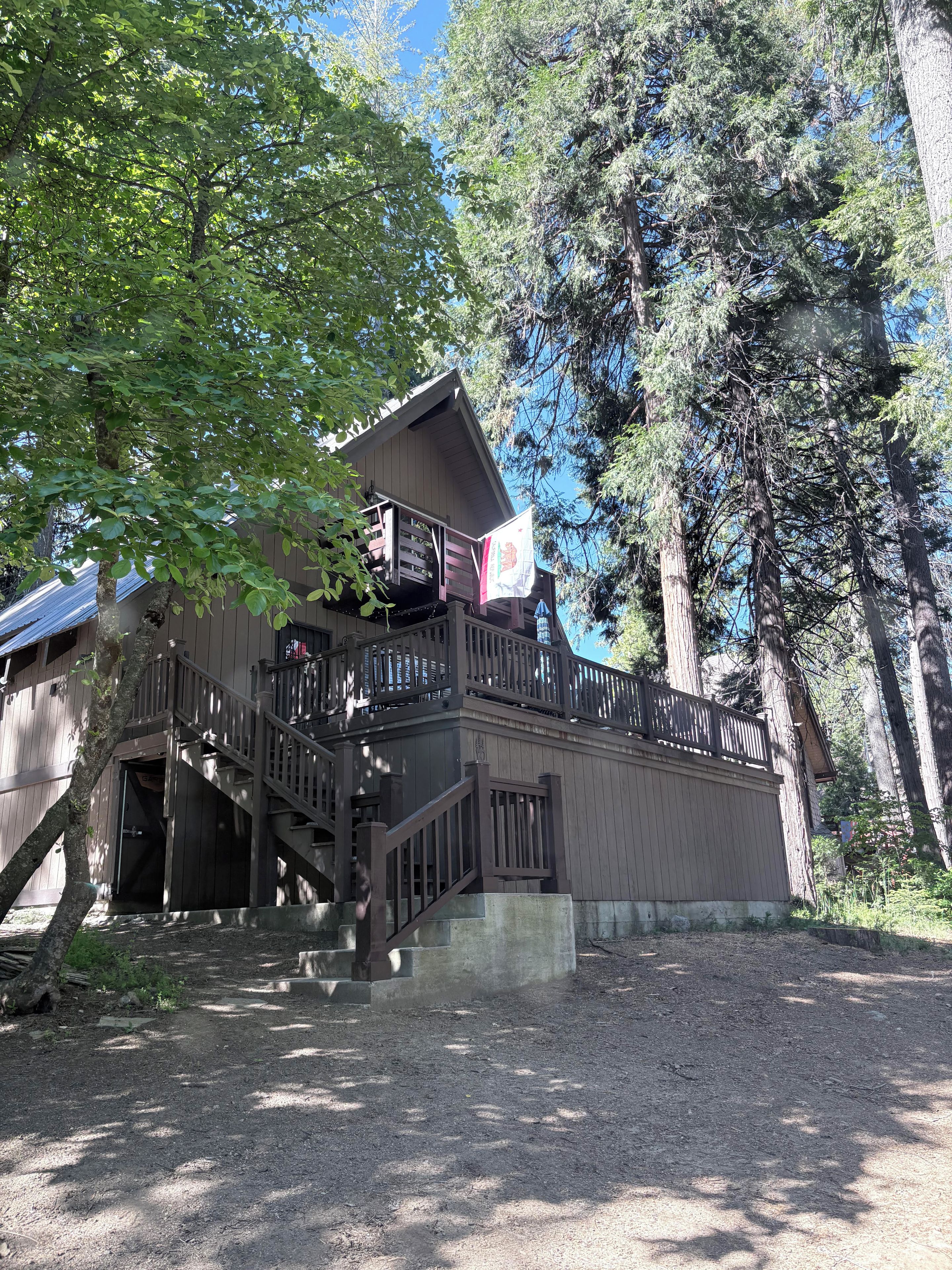 Eine Holzhütte mit einem Balkon und einer Treppe zum Eingang.