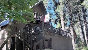 Eine Holzhütte mit einem Balkon und einer Treppe zum Eingang.