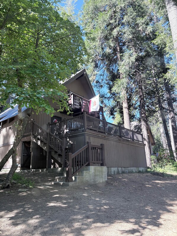 A wooden cabin with a balcony and stairs leading to the entrance.