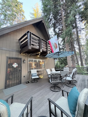 A wooden deck with outdoor seating and a California state flag.