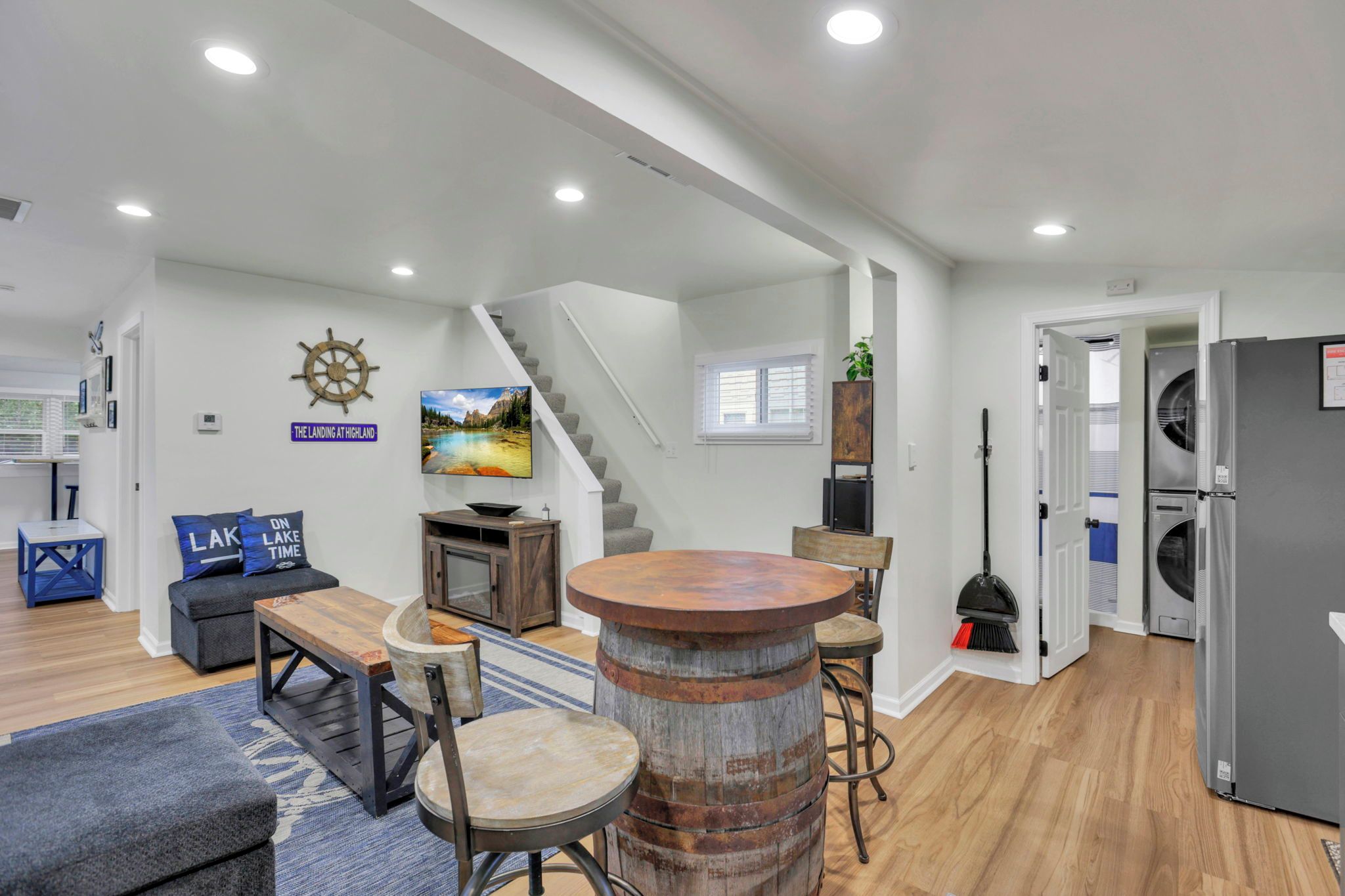 A modern living space with a staircase, seating area, and a bar.