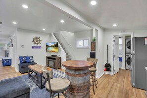 A modern living space with a staircase, seating area, and a bar.