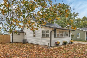 A single-story house with a front porch, a garage, and a small attached shed.