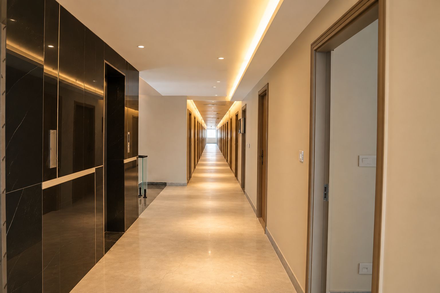 Un passadís llarg i ben il·luminat amb portes a ambdós costats, que condueix a habitacions individuals.