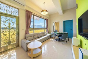 A modern living room with a sofa, a round table, a pool table, and a television. - Yilan No. 172 Random Gate (Jiaoxi)